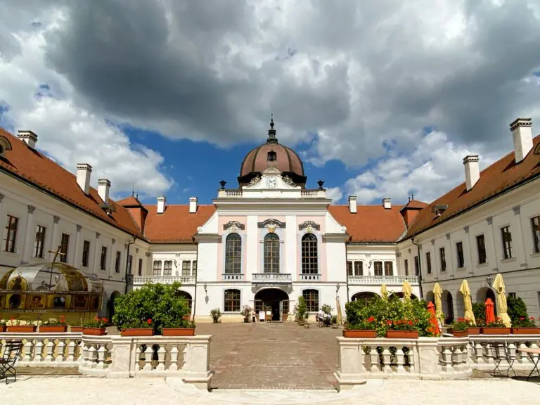 The pale baroque front of the Royal Palace of Gödöllő under a summer sky